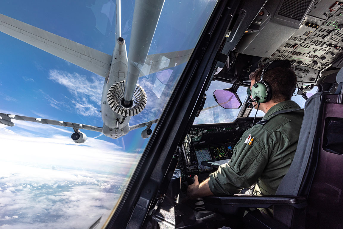 Image shows RAF aviator flying in the cockpit while looking towards the RAF Voyager aircraft being refuellled.